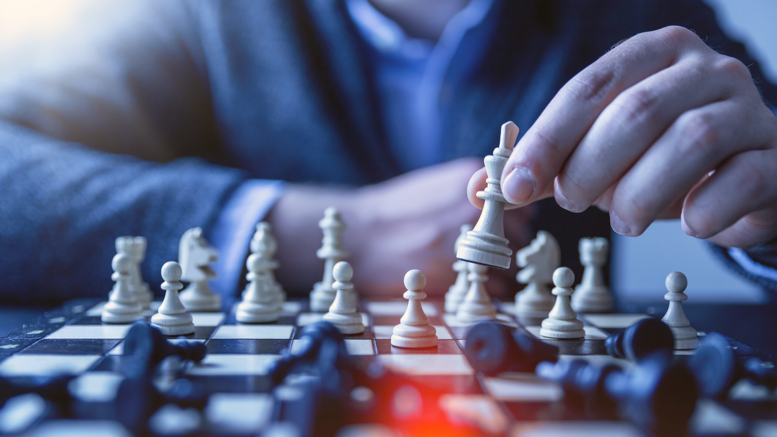 torso and hand of a man playing chess